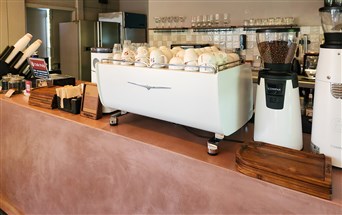 FF MicroCement wall finish at a contemporary café in Surat, showcasing seamless, matte-textured surfaces.